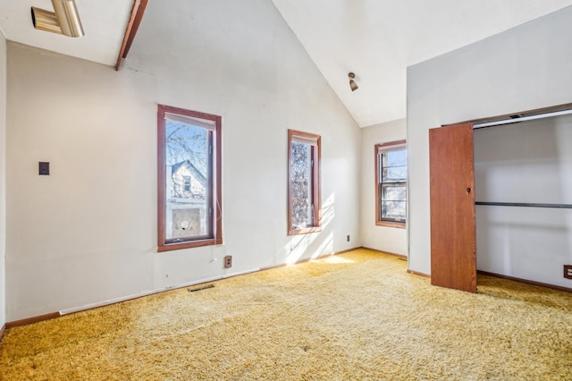 unfurnished bedroom with high vaulted ceiling, carpet flooring, visible vents, and baseboards