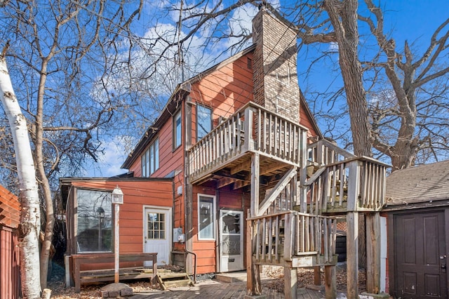 rear view of property with a chimney and a wooden deck