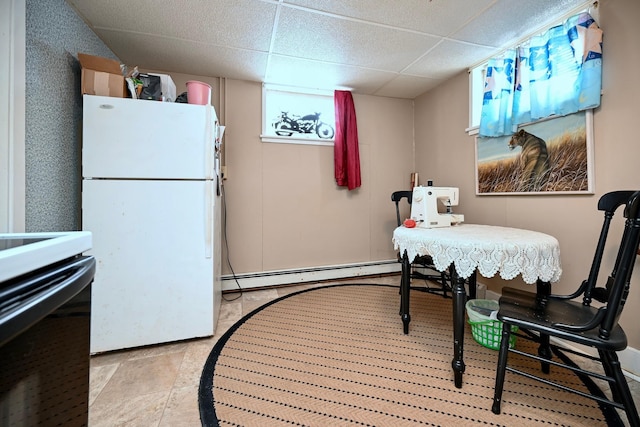 dining space with a paneled ceiling and a baseboard radiator