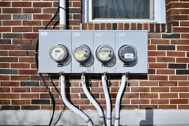 exterior details featuring electric meter and brick siding