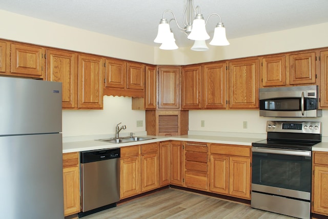 kitchen with brown cabinets, stainless steel appliances, a sink, and light countertops