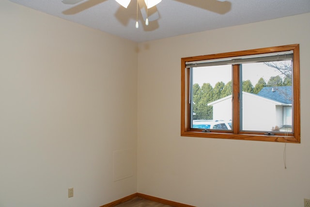 unfurnished room with a ceiling fan and baseboards