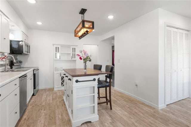 kitchen featuring open shelves, a sink, and stainless steel appliances