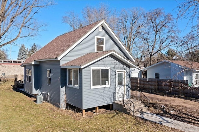 exterior space with fence, central AC, and a yard