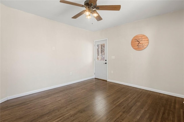 empty room with ceiling fan, dark wood-style flooring, and baseboards