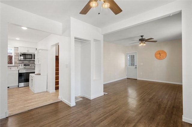 empty room featuring a ceiling fan, baseboards, wood finished floors, and recessed lighting