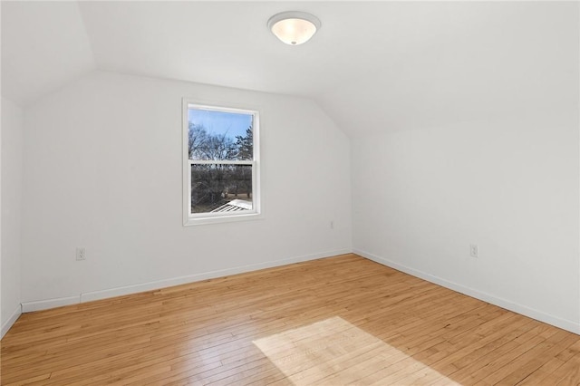 additional living space featuring lofted ceiling, baseboards, and light wood finished floors