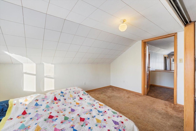 unfurnished bedroom with carpet, lofted ceiling, and baseboards