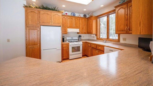 kitchen featuring recessed lighting, under cabinet range hood, white appliances, a sink, and light countertops