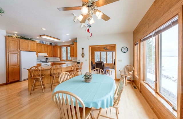 dining room with light wood-style floors, recessed lighting, plenty of natural light, and baseboards