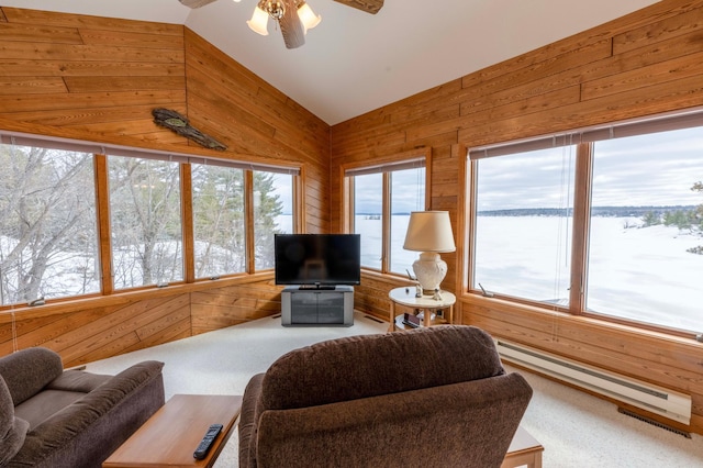 living room featuring a baseboard radiator, vaulted ceiling, wood walls, and ceiling fan