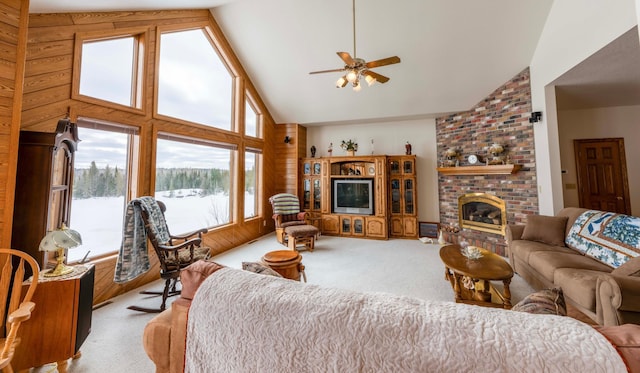 living area featuring a brick fireplace, a ceiling fan, high vaulted ceiling, and carpet flooring