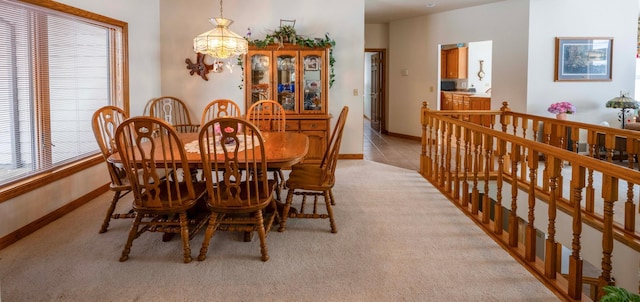 dining room with light colored carpet and baseboards