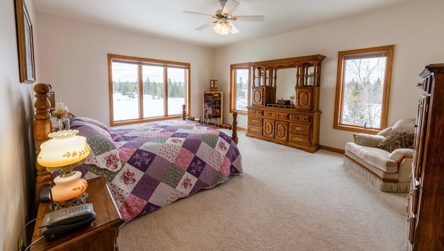 carpeted bedroom with ceiling fan and baseboards