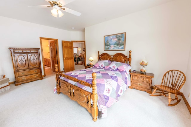 bedroom with carpet floors, a ceiling fan, baseboards, and ensuite bathroom