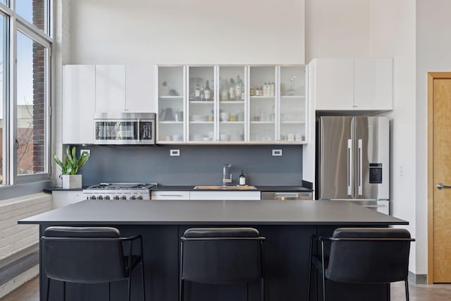 kitchen with white cabinets, a wealth of natural light, stainless steel appliances, and a sink