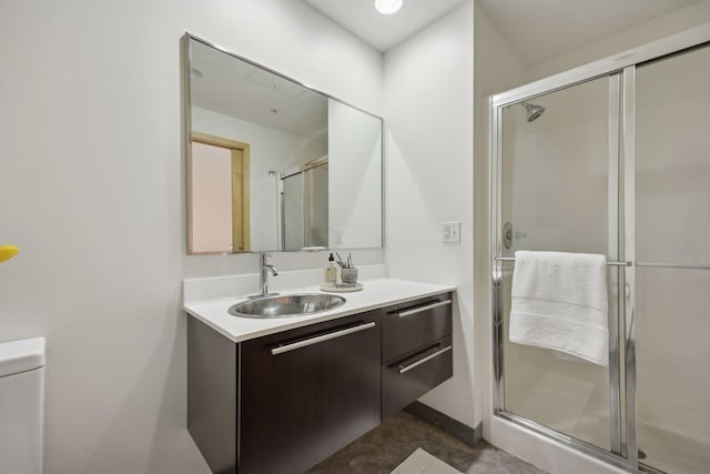 bathroom featuring toilet, a shower stall, and vanity