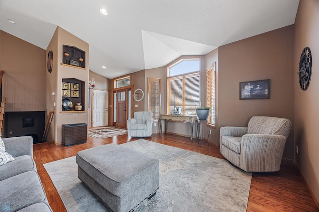 living room with vaulted ceiling and wood finished floors