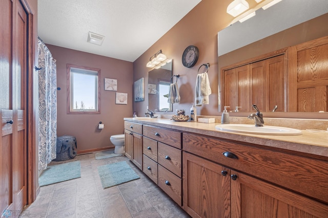 full bath featuring toilet, plenty of natural light, a sink, and visible vents