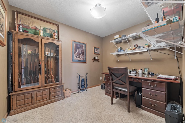 office area with carpet floors, baseboards, and a textured ceiling