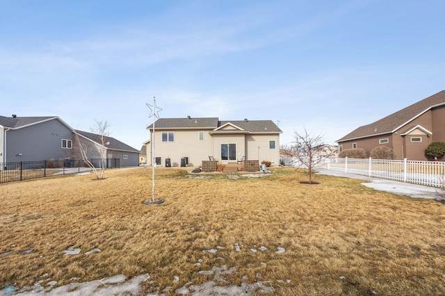 back of house with a fenced backyard and a yard