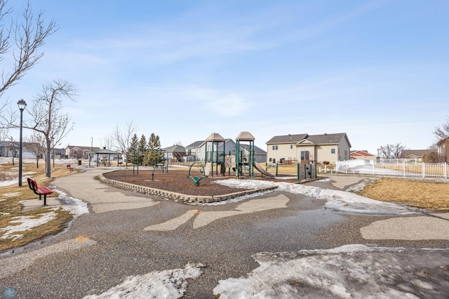 communal playground featuring a residential view and fence