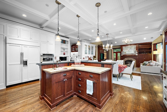 6155 Murray Ct, Shorewood, MN 55331 - kitchen featuring paneled refrigerator, stainless steel oven, coffered ceiling, dark wood-type flooring, and an island with sink