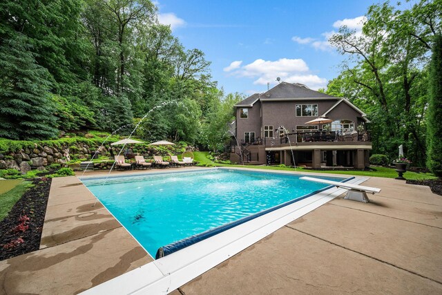 6155 Murray Ct, Shorewood, MN 55331 - swimming pool with stairs, a wooden deck, a patio area, and a diving board