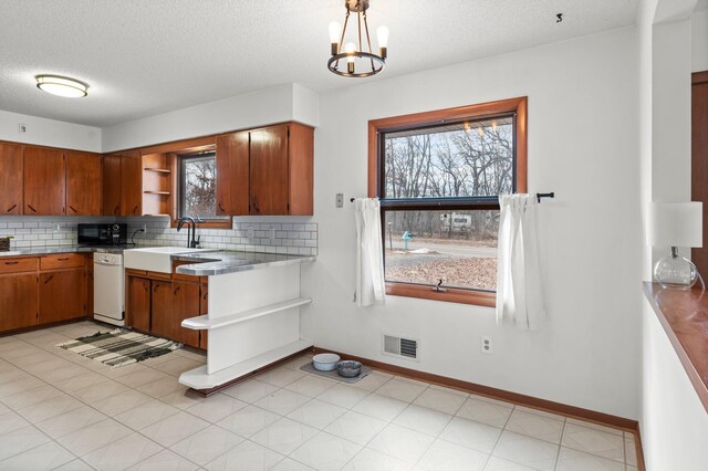 kitchen with black microwave, white dishwasher, a sink, visible vents, and open shelves