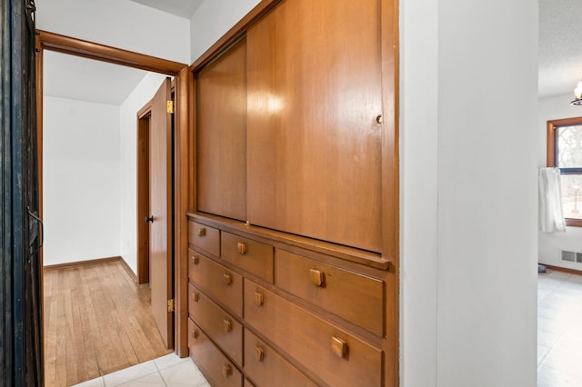 corridor featuring visible vents and baseboards