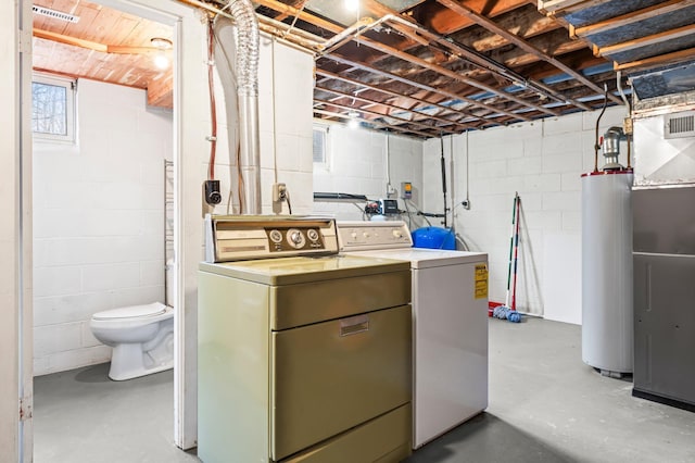 washroom with laundry area, washing machine and dryer, and water heater