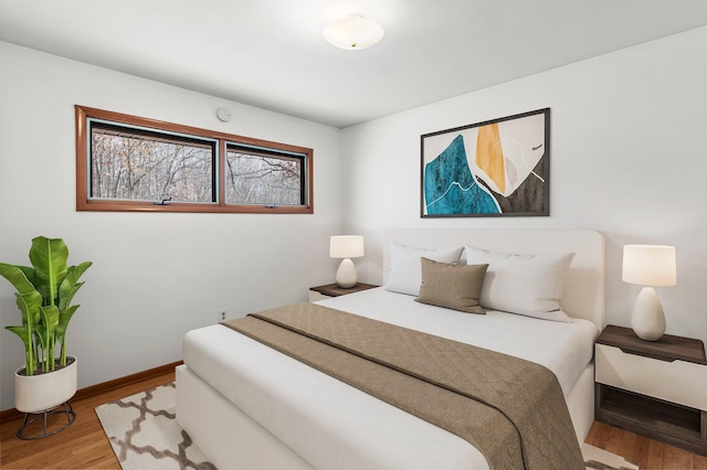 bedroom with baseboards and wood finished floors
