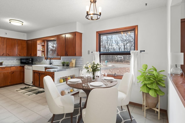 kitchen with decorative backsplash, open shelves, white dishwasher, and a sink