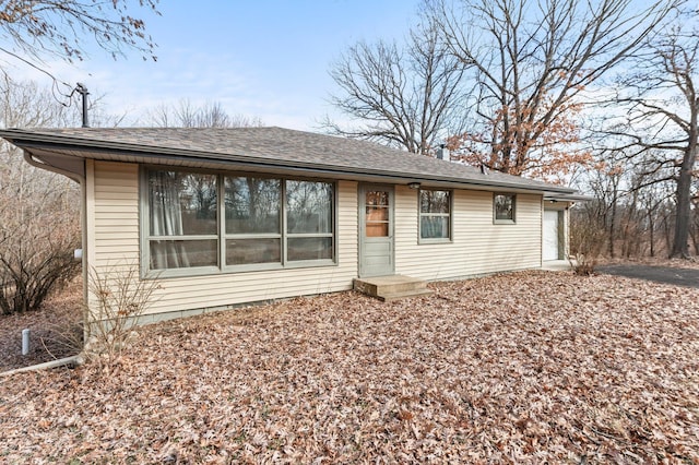 view of front of property with driveway, roof with shingles, and an attached garage