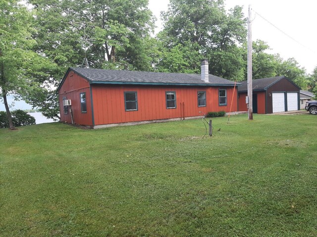 43404 Bills Beach Rd, Edna Twp, MN 56528 - view of front facade with a chimney, a front lawn, a garage, and a shingled roof