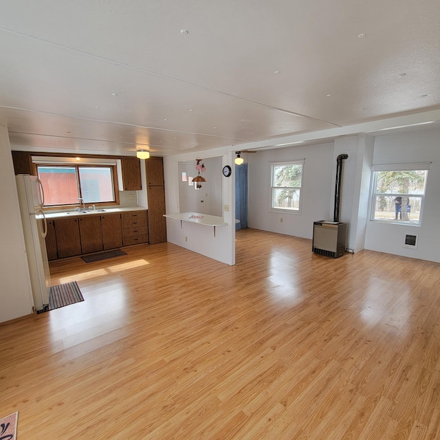 43404 Bills Beach Rd, Edna Twp, MN 56528 - unfurnished living room featuring light wood finished floors, a wood stove, and a sink