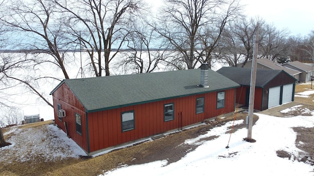 43404 Bills Beach Rd, Edna Twp, MN 56528 - snow covered property featuring a shingled roof, a chimney, and a detached garage