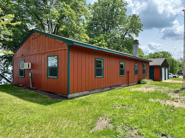 43404 Bills Beach Rd, Edna Twp, MN 56528 - view of property exterior with a chimney, a lawn, a garage, and a wall mounted air conditioner
