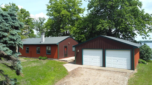 43404 Bills Beach Rd, Edna Twp, MN 56528 - view of front of house featuring an outbuilding, a detached garage, a front lawn, and a chimney