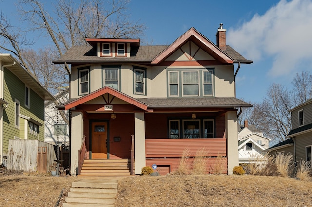 view of front of property with a porch, roof with shingles, a chimney, and stucco siding