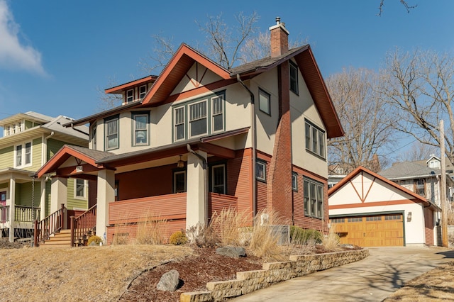 tudor house featuring covered porch, a chimney, and stucco siding