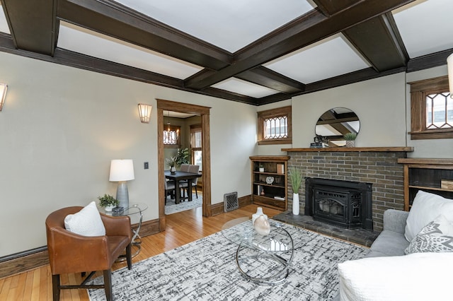 living room featuring coffered ceiling, visible vents, baseboards, light wood-type flooring, and beamed ceiling