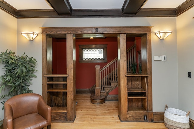 stairs featuring baseboards, ornamental molding, and wood finished floors