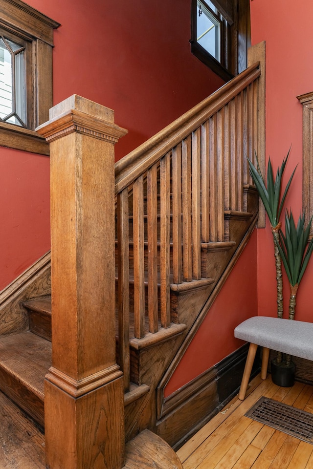 stairs featuring hardwood / wood-style flooring and plenty of natural light