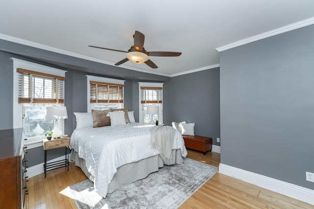 bedroom featuring baseboards, multiple windows, light wood-type flooring, and crown molding