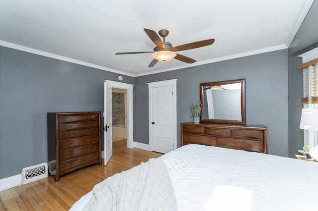 bedroom featuring light wood-style floors, baseboards, visible vents, and crown molding