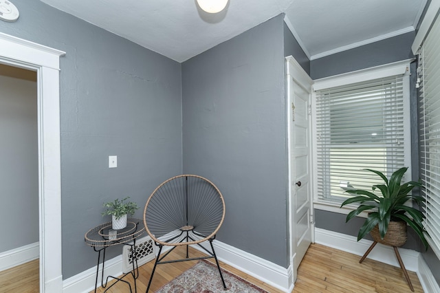 sitting room featuring crown molding, wood finished floors, and baseboards