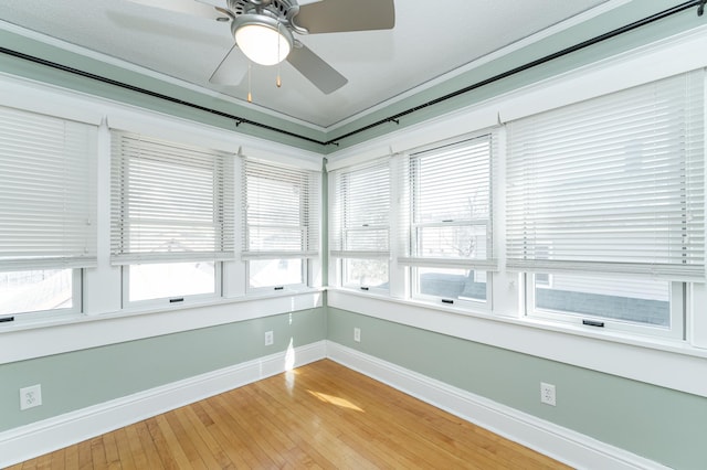 unfurnished sunroom featuring ceiling fan