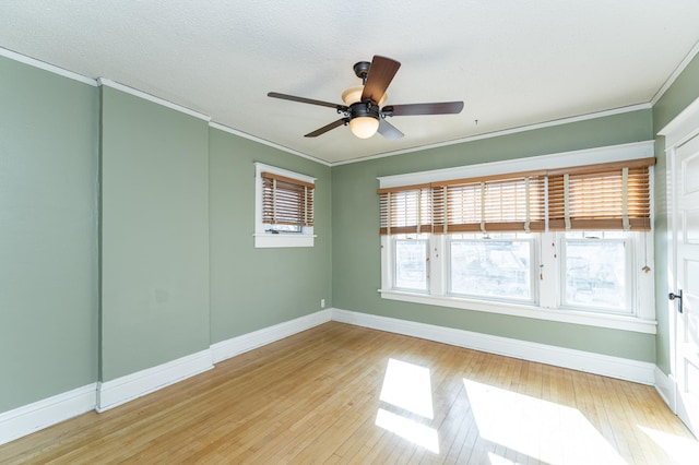 unfurnished room featuring ornamental molding, light wood-style flooring, and baseboards