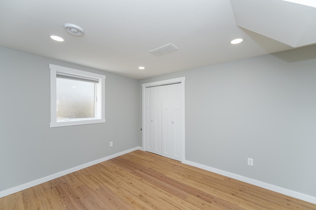 unfurnished room with light wood-type flooring, visible vents, baseboards, and recessed lighting